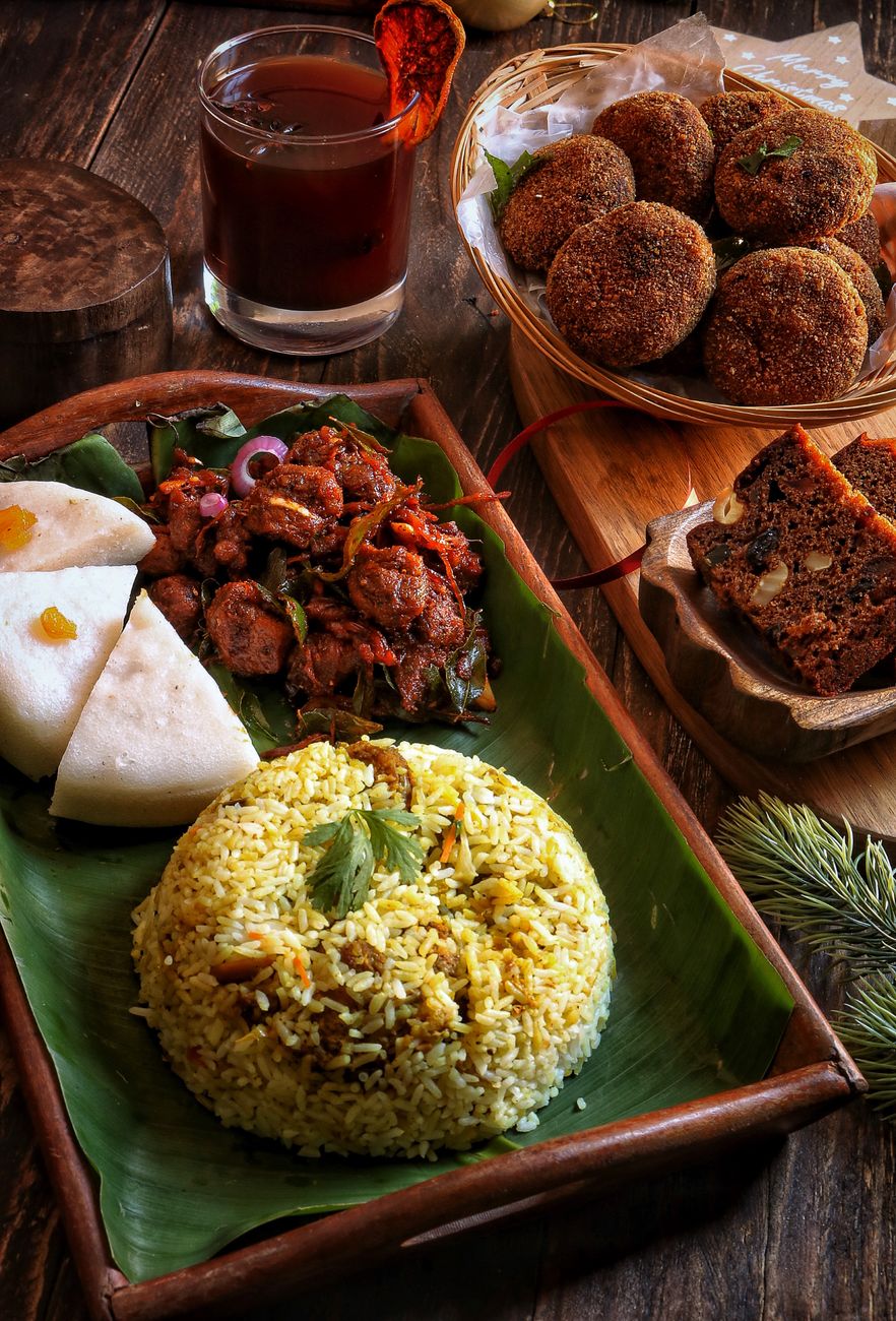 A beautifully arranged meal featuring rice, sides, and a drink on a wooden table.