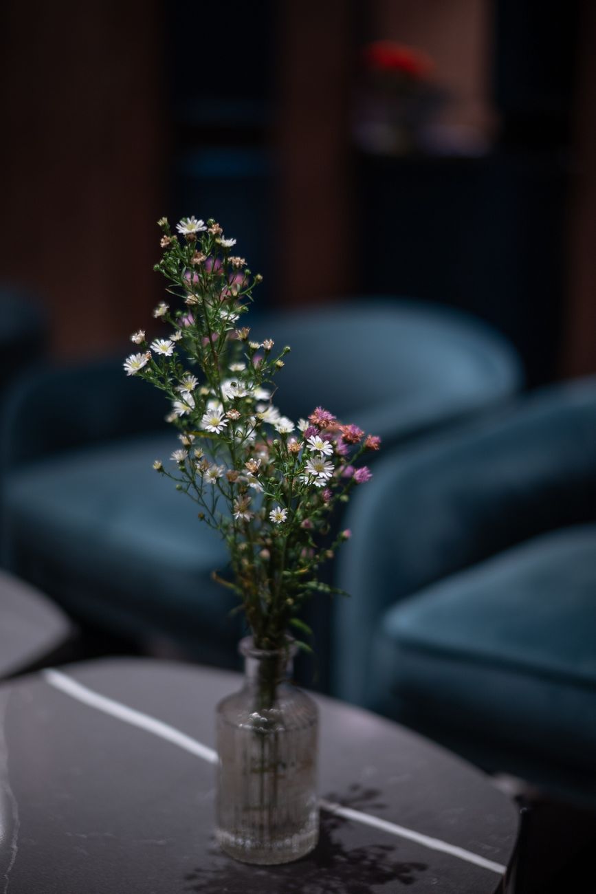 Delicate wildflowers in a glass vase add charm to a sophisticated lounge setting. Perfect for interior decor inspiration.