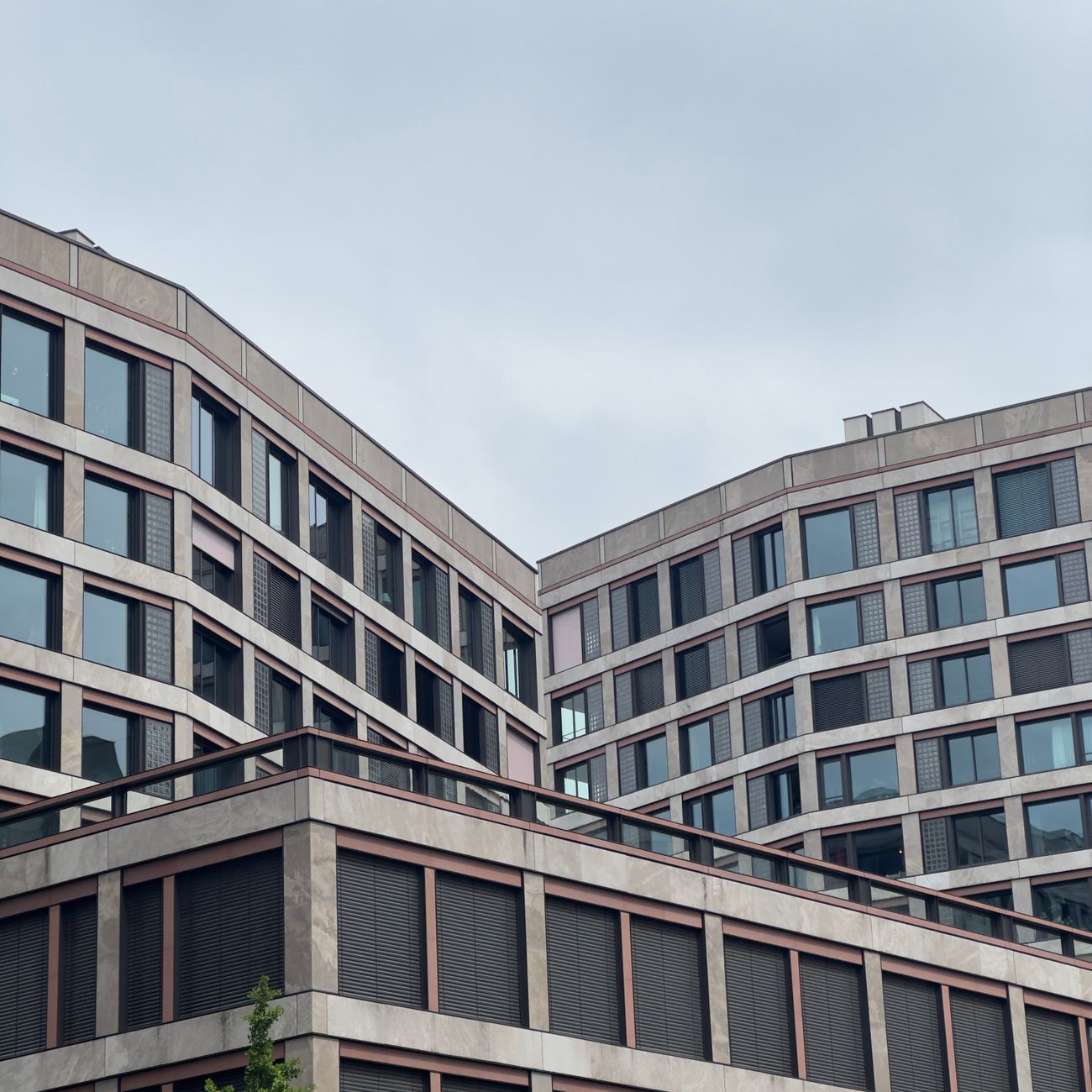 Low-angle view of modern buildings in Zürich, Switzerland under an overcast sky.
