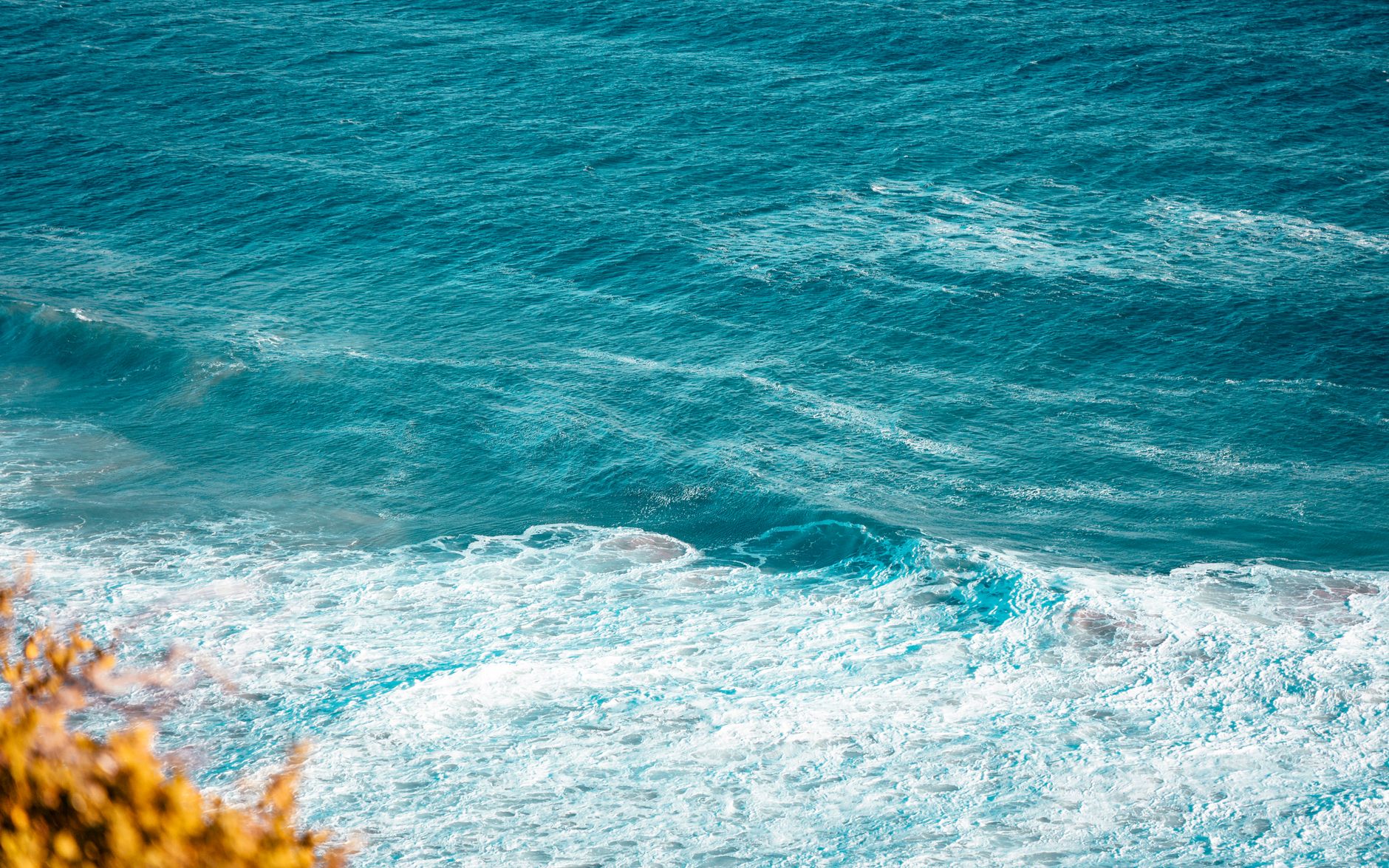 A dynamic view of ocean waves with a bright blue hue, invoking a sense of tranquility.