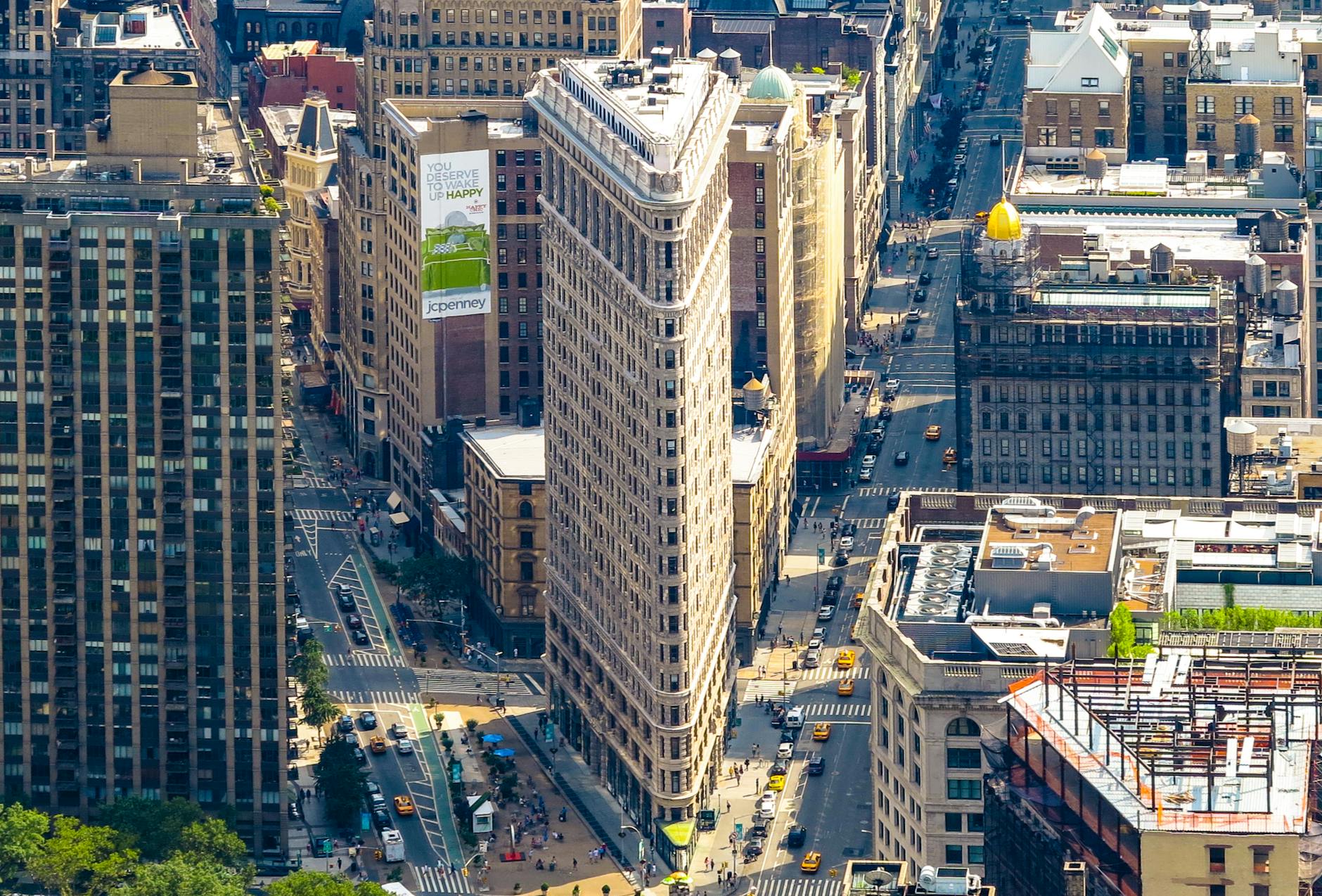 Stunning aerial view of the iconic Flatiron Building surrounded by Manhattan's bustling cityscape.