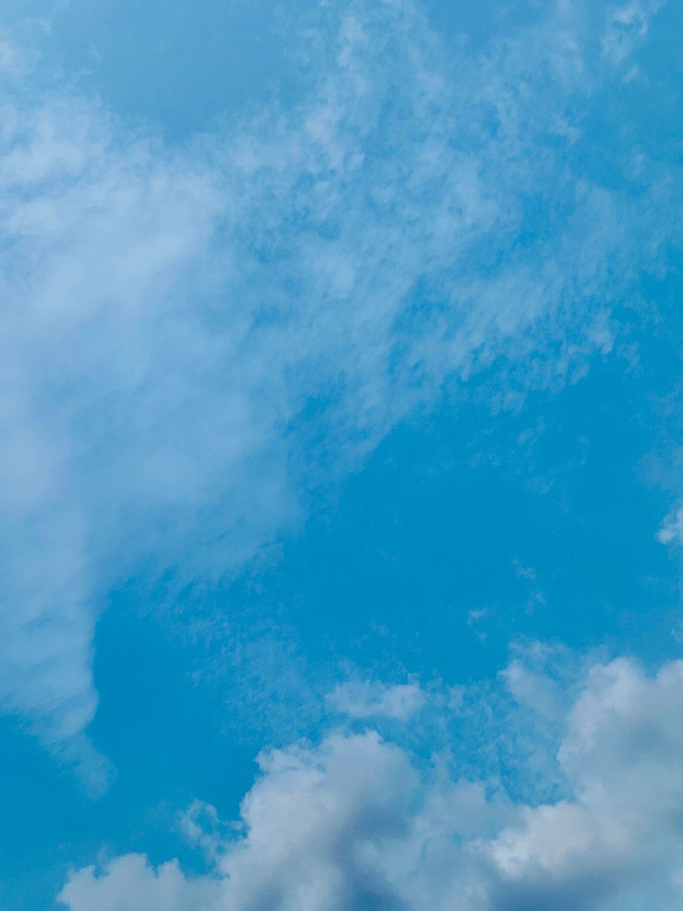 A serene blue sky with soft clouds creating a peaceful ambiance.