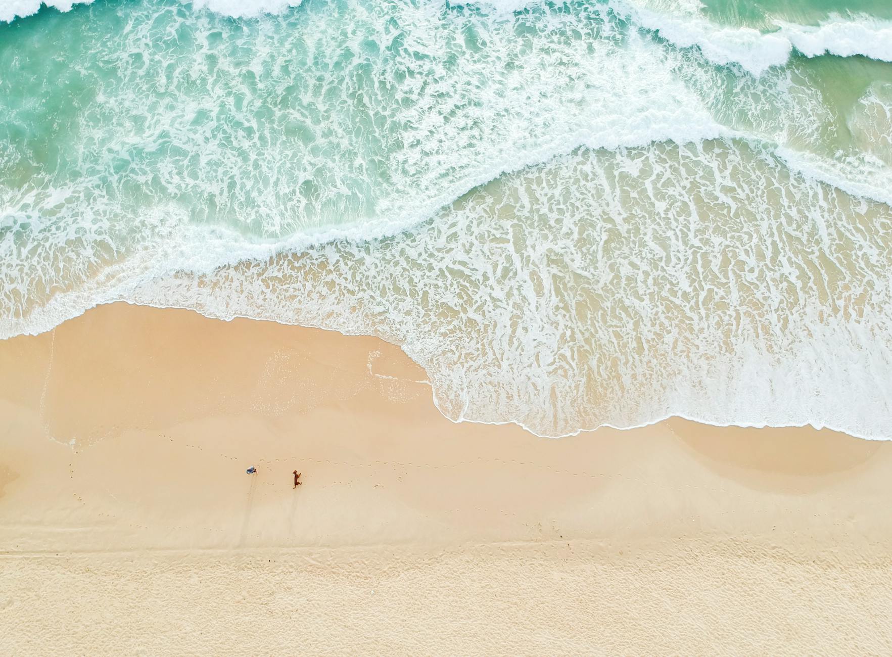 Serene aerial view of Castaways Beach in Queensland with gentle waves and sandy shores.