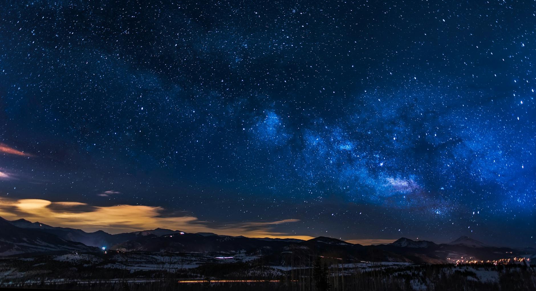 A breathtaking view of the Milky Way galaxy illuminating the night sky over mountains.