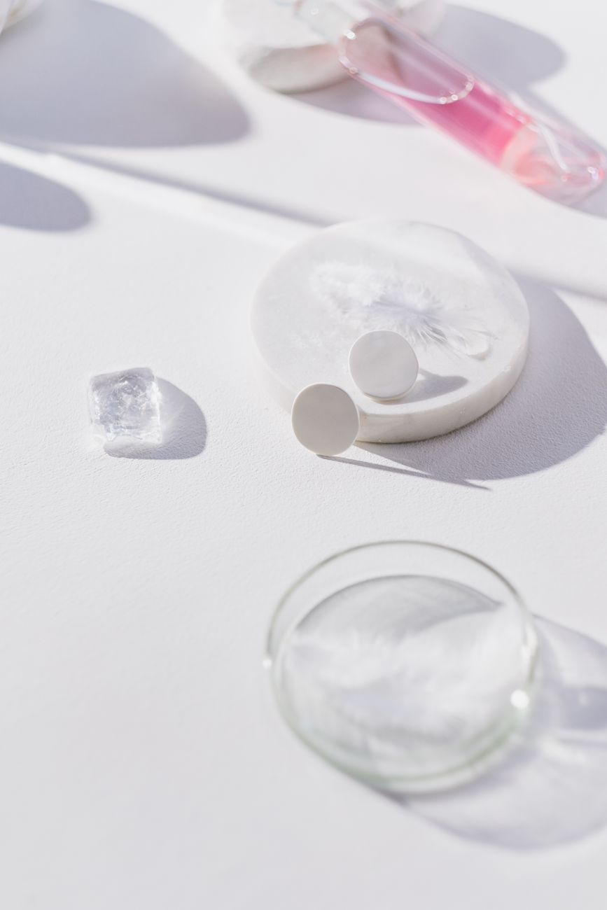 Close-up of laboratory equipment on white background with petri dish and flasks, depicting scientific research.